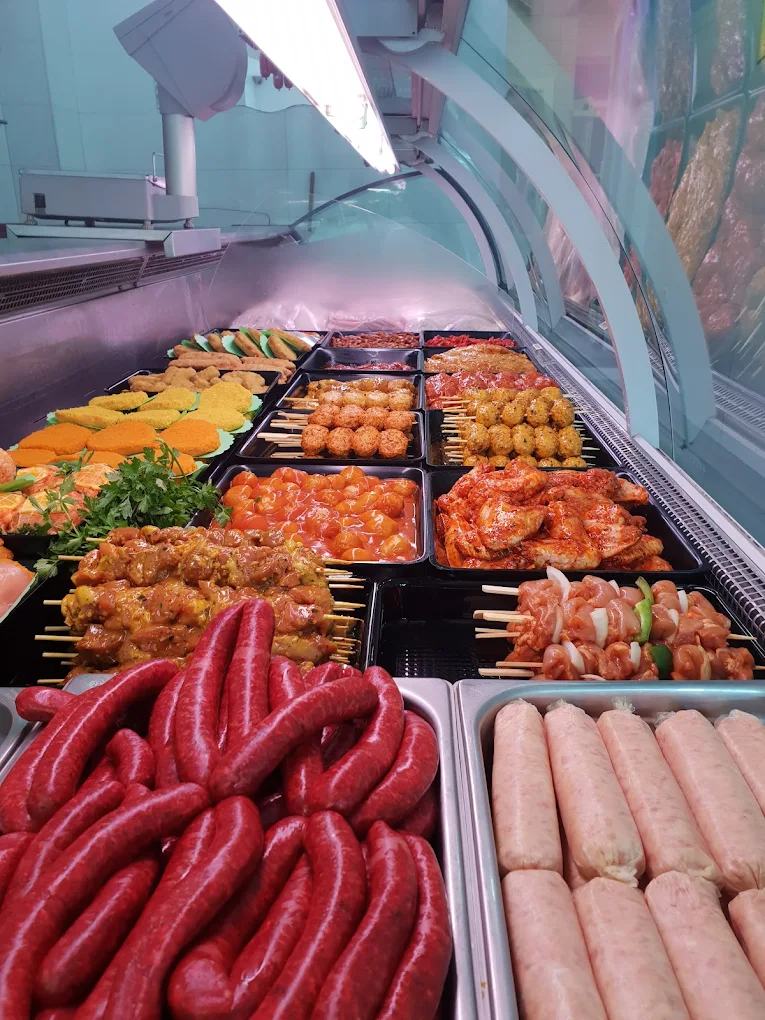 Vitrine garnie de la Boucherie Amine à Ottignies — merguez, brochettes et marinades